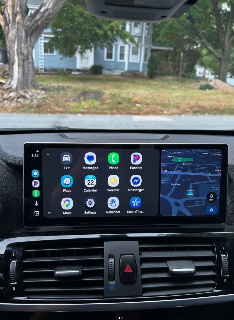 Car dashboard displaying Apple CarPlay interface with apps and navigation map, view of residential house through windshield